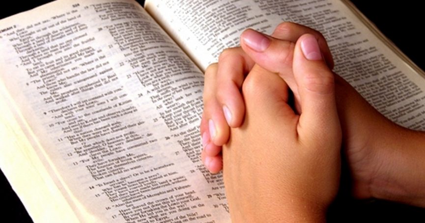 praying hands on Bible